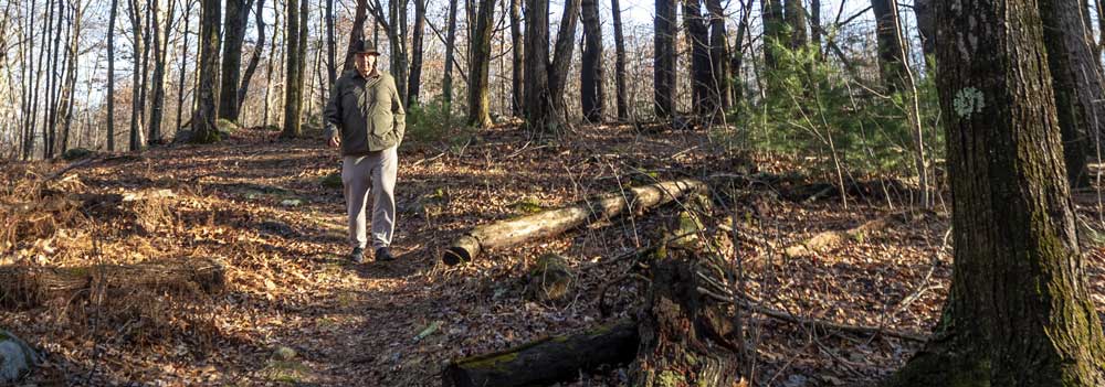 Naugatuck Mayor Pete Hess walks with Connecticut Water staff while discussing plans to develop a formal trail on a parcel the borough recently purchased from Connecticut Water.